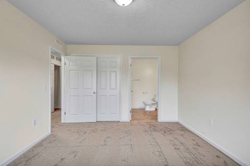 A room with a carpeted floor and a white door.