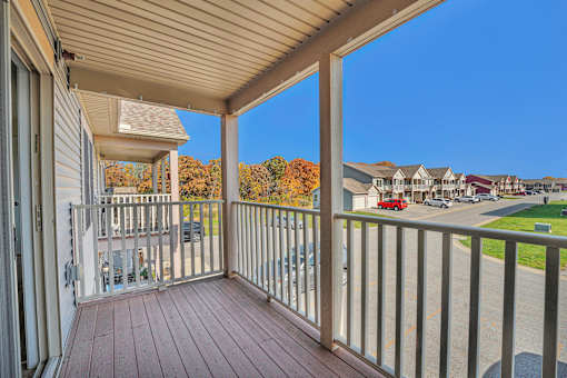 A balcony with a metal railing and a wooden floor.