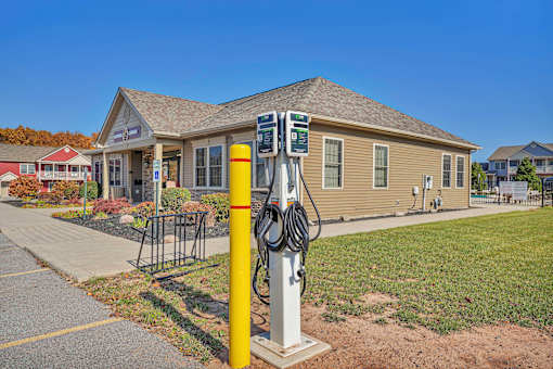 A yellow and white charging station sits in front of a building.