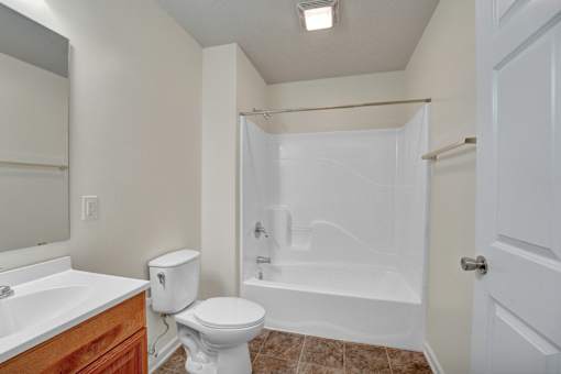 A white toilet sits next to a sink in a small bathroom.