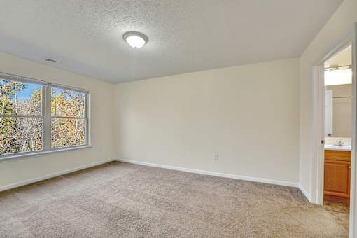 A room with a carpeted floor and a window.