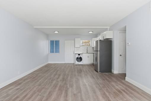 A kitchen with a refrigerator, dishwasher, and oven.