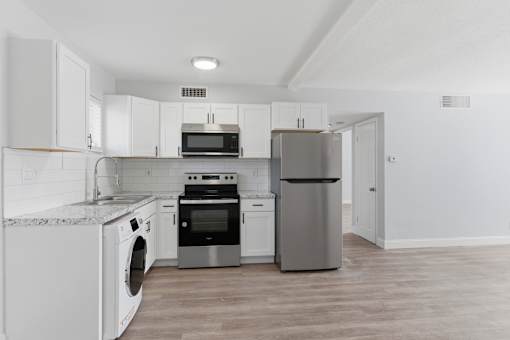 A kitchen with white cabinets and stainless steel appliances.