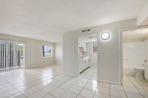 A white tiled bathroom with a toilet and sink.