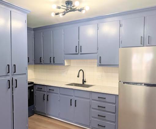 A kitchen with a sink and a refrigerator.