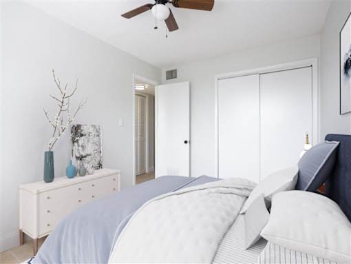 a white bedroom with a bed and a ceiling fan