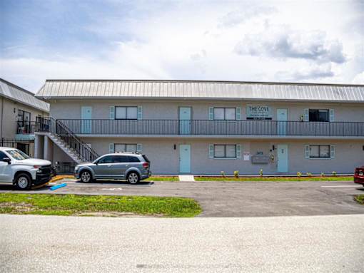 a building with a parking lot and cars in front of it