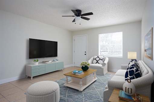a living room with a ceiling fan and a tv