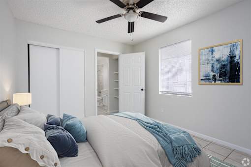 a bedroom with a large bed and a ceiling fan