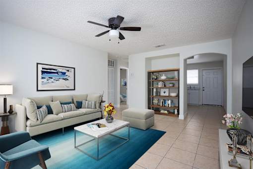 a living room with a couch and a coffee table and a ceiling fan