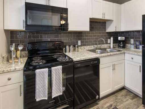a kitchen with black appliances and white cabinets