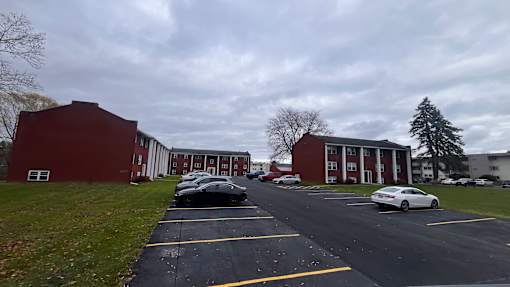 A parking lot with cars and a building in the background.