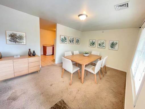 A dining room with a wooden table and chairs.