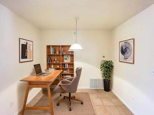 A room with a desk, chair, and bookshelf.