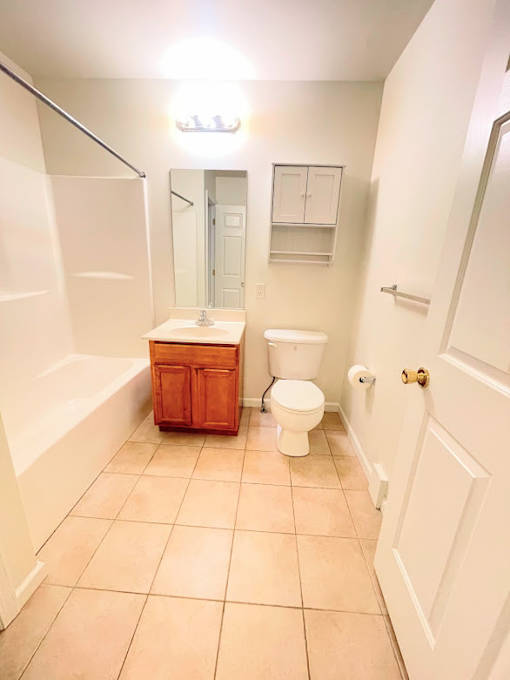 A white bathroom with a toilet, sink, and bathtub.
