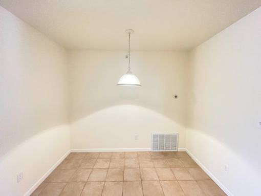 A room with a tiled floor and a hanging light fixture.