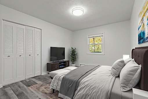 A bedroom with a bed, a television, and a window.