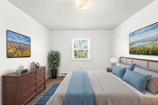 A bedroom with a large bed and a wooden dresser.