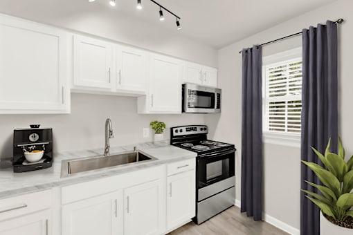 a kitchen with white cabinetry and black appliances and a sink