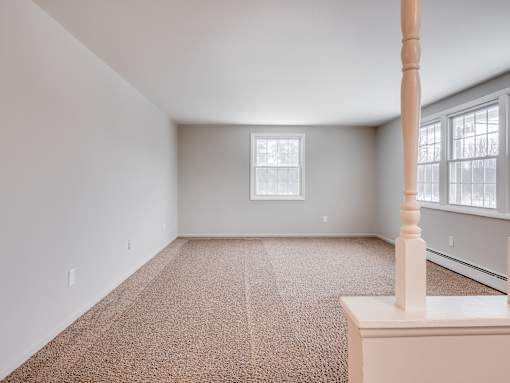 A room with a carpeted floor and a window.