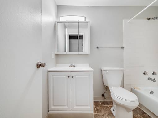 A white bathroom with a toilet, sink, and bathtub.