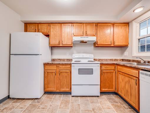 A kitchen with wooden cabinets and white appliances.