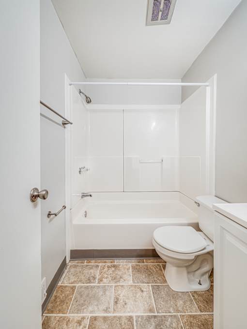 A white bathroom with a toilet, tub, and sink.