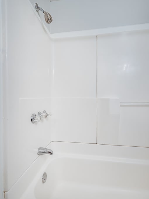A white bathroom with a tub and shower.