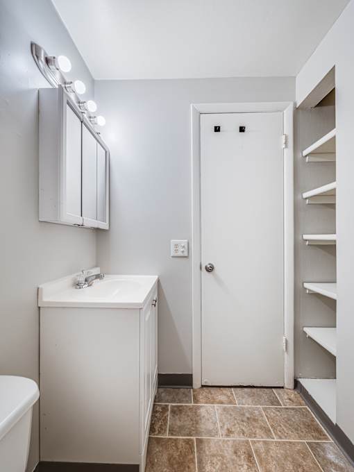 A white bathroom with a toilet, sink, and mirror.