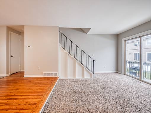 A room with a staircase and a sliding glass door.
