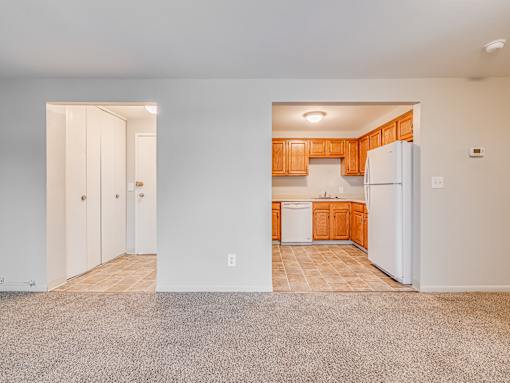 A kitchen with white appliances and wooden cabinets.