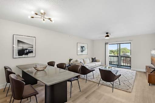 A modern dining room with a glass table and chairs.