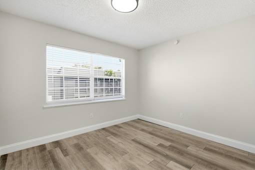 A room with a window and wooden flooring.