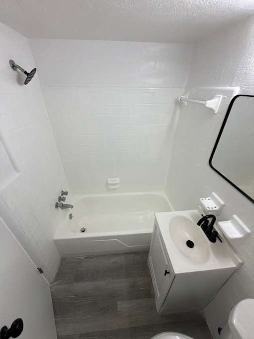 A white bathroom with a tub, sink and toilet.