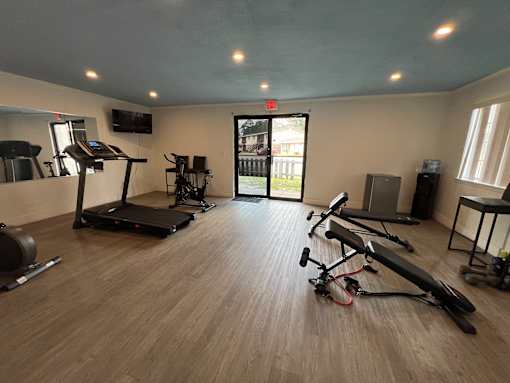 A gym with treadmills, exercise bikes, and weights.