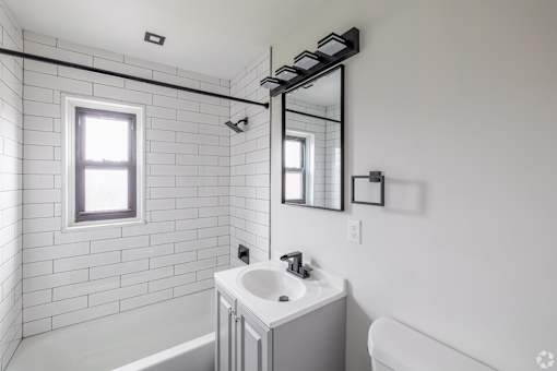 A white bathroom with a white tub and sink.