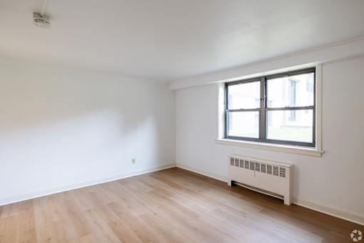 A room with a window and a radiator on the wall.