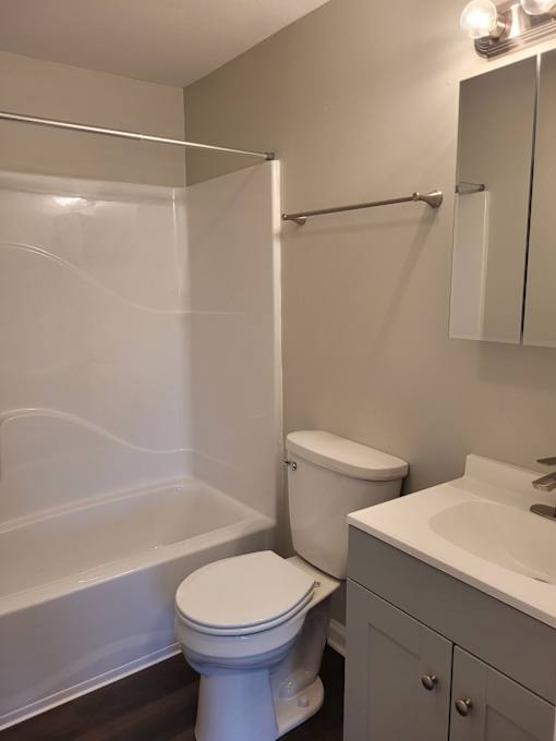 A white toilet sits next to a white sink in a bathroom.