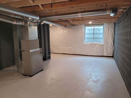 A room with a white refrigerator and a window covered with a white sheet.