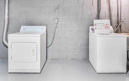 Two white appliances in a room with a white wall.