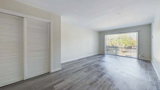 A room with a sliding door and a balcony.