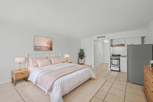 A bedroom with a large bed and a painting on the wall.