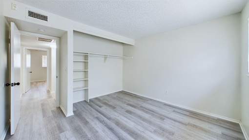 A room with a white door and a grey floor.