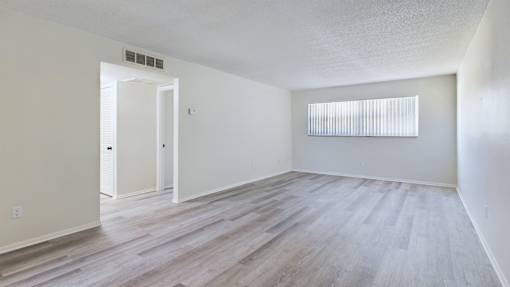 A room with a white door and a window with blinds.