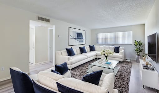 A living room with a white couch and a coffee table.
