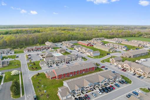 an aerial view of a neighborhood with cars parked in a parking lot
