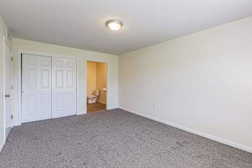 a room with carpet and a door to a bathroom