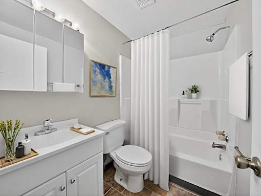 A white bathroom with a toilet, sink, and bathtub.
