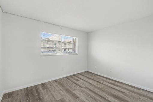 Empty room with a window showing a building outside.
