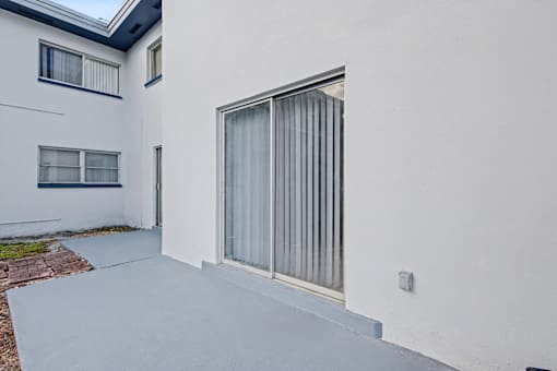 A white house with a grey door and windows.